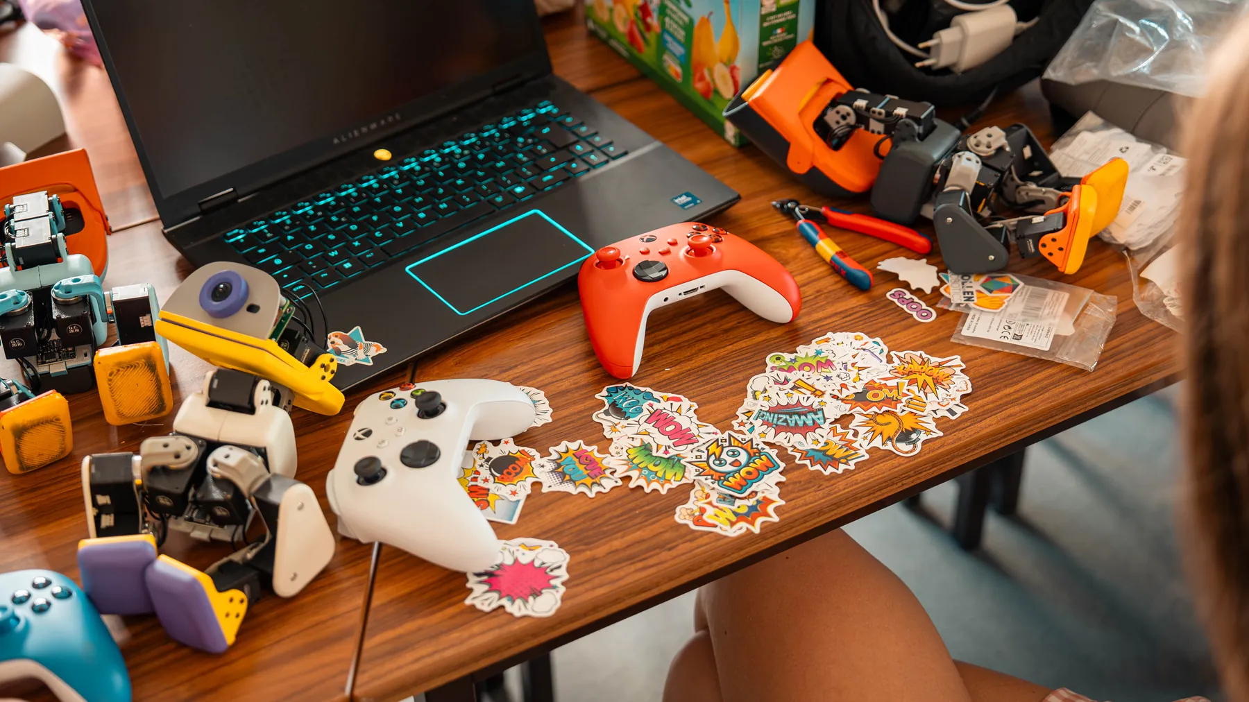 Overhead view of a desk with Microducks, a game controller and a sticker sheet